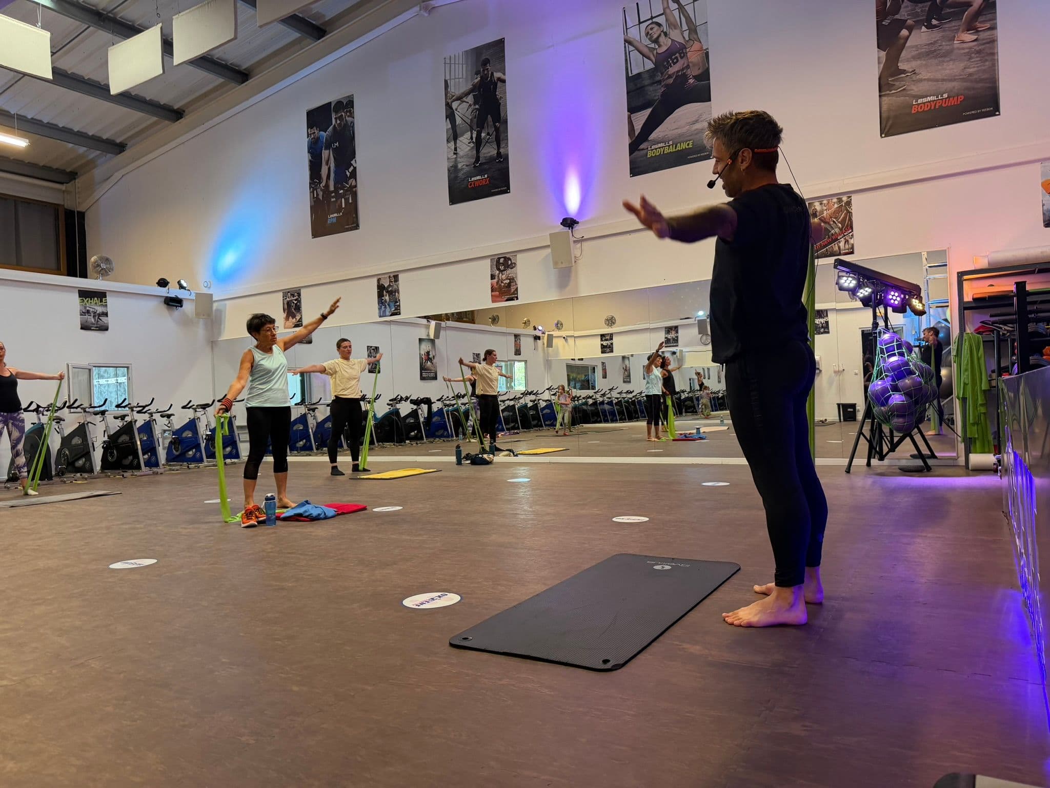 Cours collectif fitness avec coach et plusieurs participants dans la salle OXYGÈNE Fitness Saint-Macaire.