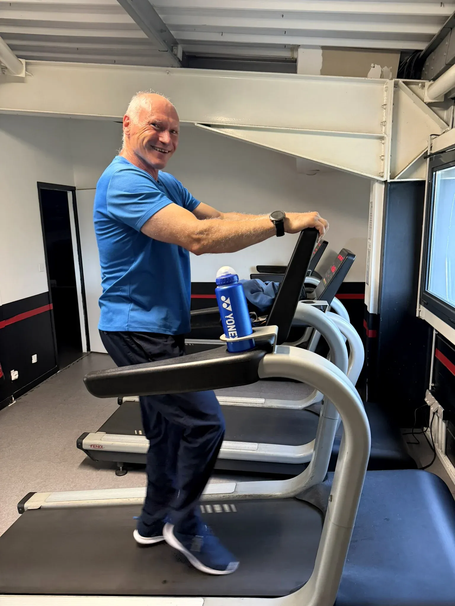 Adhérent souriant sur un tapis de course dans l’espace cardio d’OXYGÈNE Fitness Saint-Macaire.
