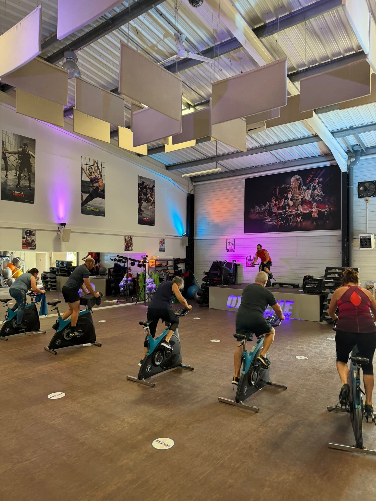 Adhérents participant à un cours collectif de vélo dans la salle Fitness d’OXYGÈNE Saint-Macaire.