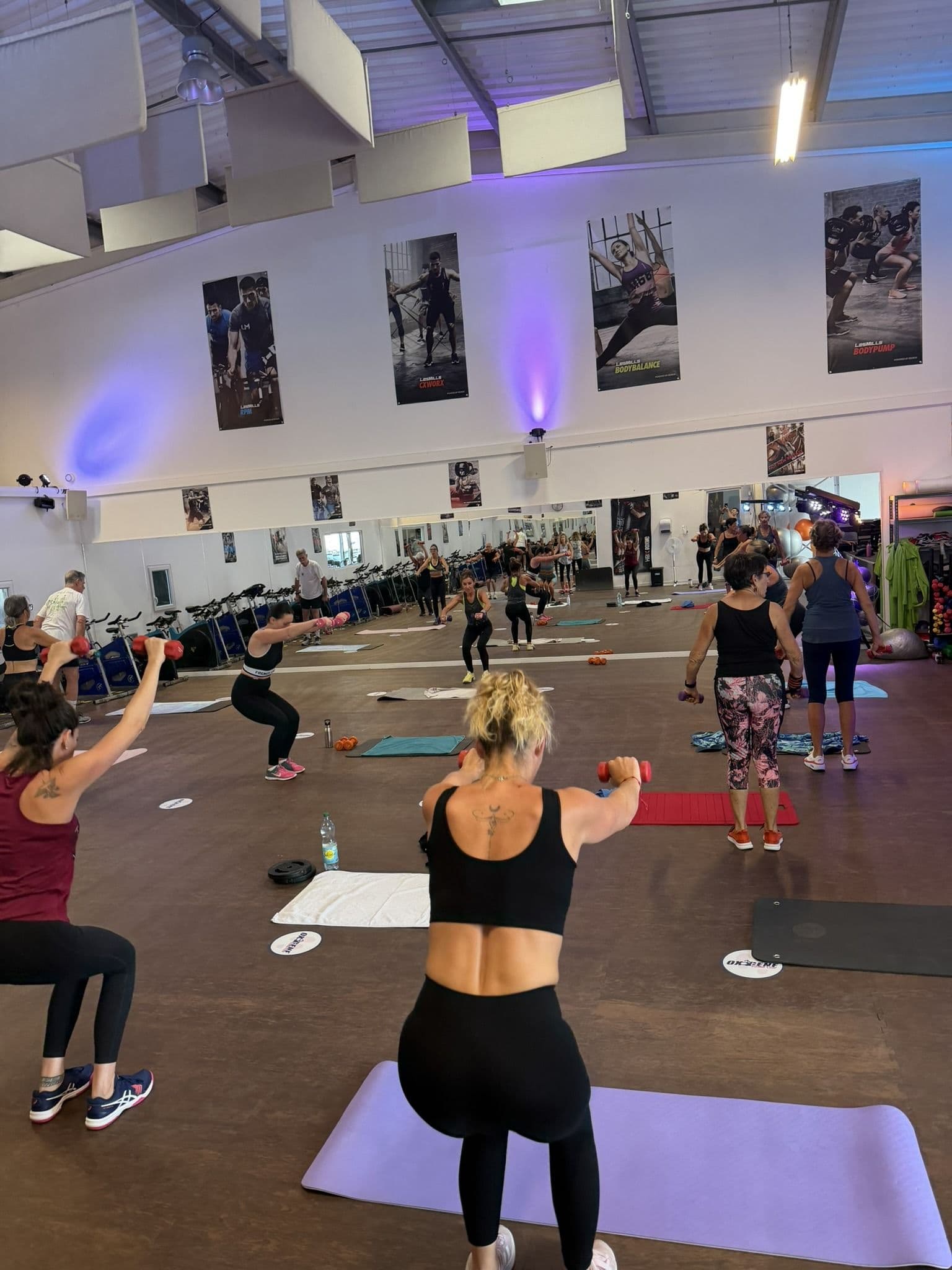 Adhérentes participant à un cours collectif CAF avec haltères dans la salle Fitness d’OXYGÈNE Saint-Macaire.