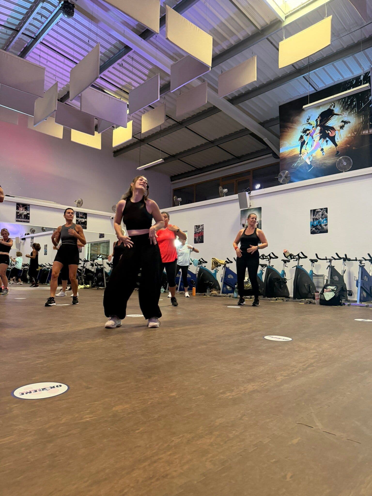 Un groupe d’adhérents s’entraîne pendant un cours collectif chorégraphié chez OXYGÈNE Fitness Saint-Macaire.