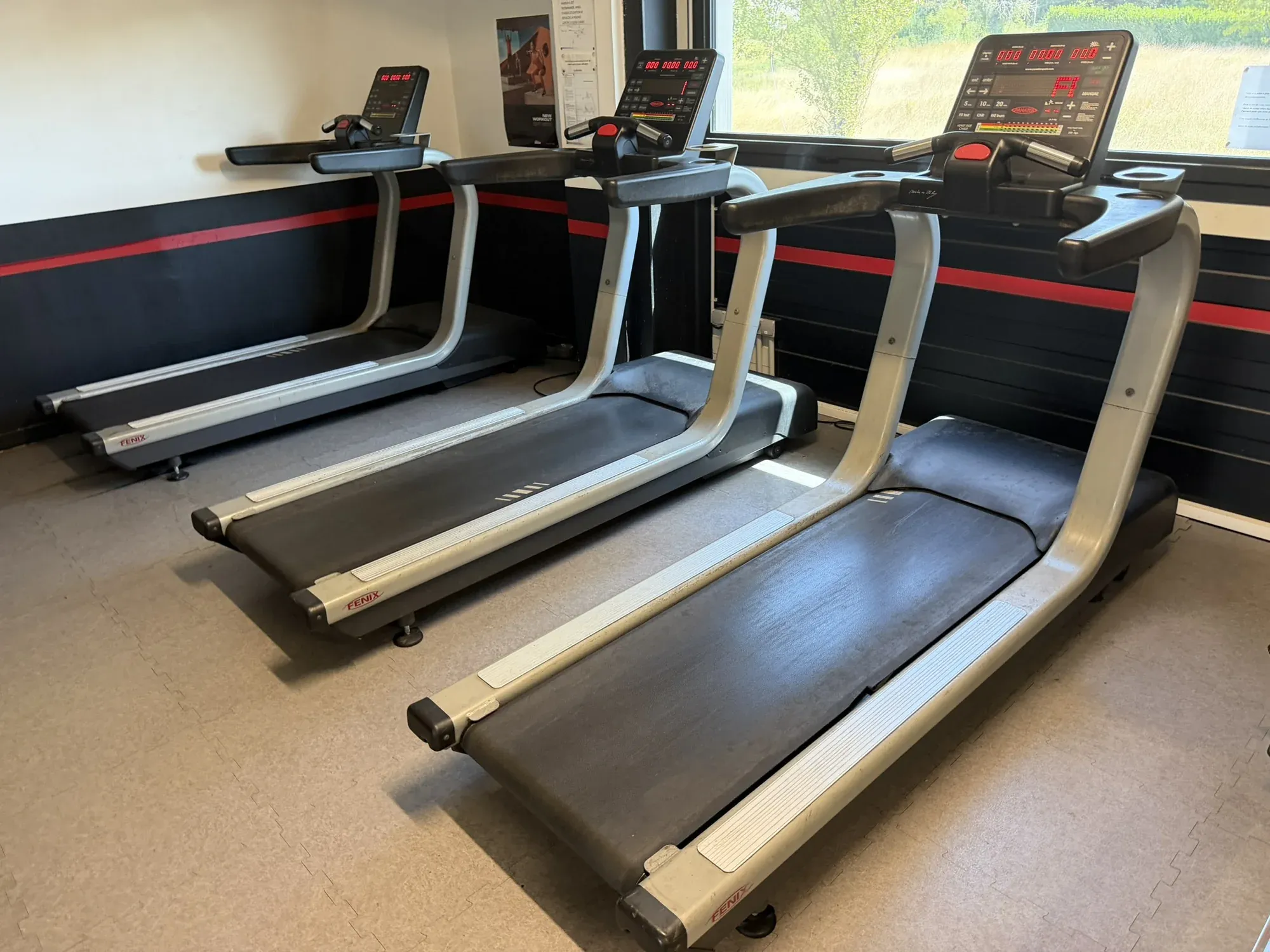 Rangée de tapis de course du club OXYGÈNE Fitness.