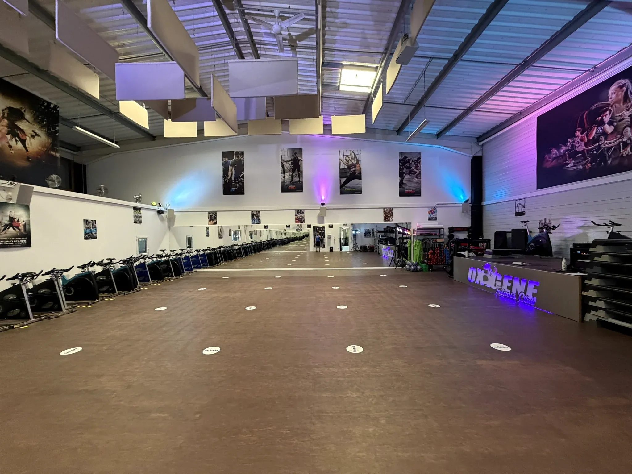 Vue d’ensemble de la salle fitness d’OXYGÈNE Fitness Saint-Macaire avec espace de cours, vélos et miroir.