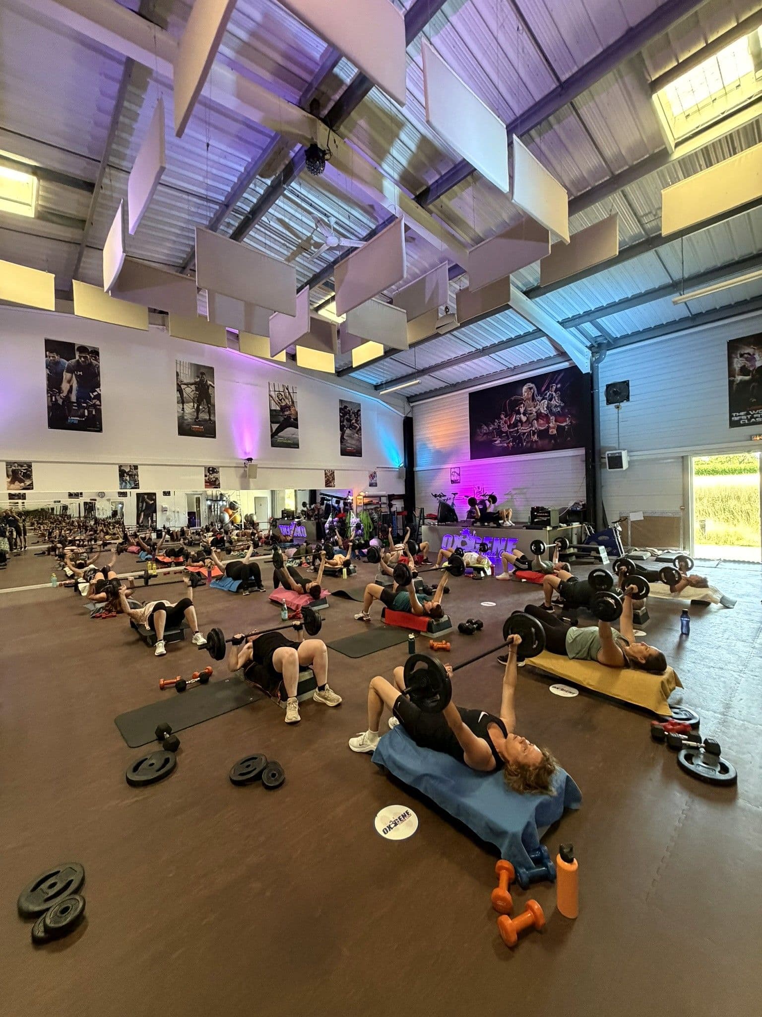 Séance collective de renforcement avec barres dans la salle Fitness OXYGÈNE